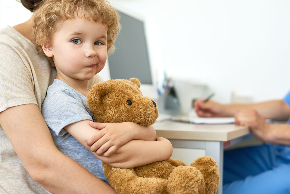 Child with teddy bear preparing for surgery